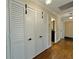 Long hallway with hardwood floors and white louvered doors at 100 Bluff View Dr # 208B, Belleair Bluffs, FL 33770