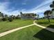 Landscaped grounds with walkways, palm trees, and building view at 100 Bluff View Dr # 208B, Belleair Bluffs, FL 33770
