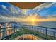 Oceanfront balcony showcasing sunset views and comfortable wicker furniture at 1560 Gulf Blvd # 1107, Clearwater Beach, FL 33767