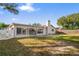 Home's back exterior, sliding glass doors, and grassy yard at 2502 Indigo Dr, Dunedin, FL 34698