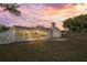 Back exterior view of home at sunset, showing patio and yard at 2502 Indigo Dr, Dunedin, FL 34698