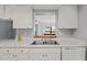 Kitchen boasts white cabinets, updated countertops, and a pass-through window at 2502 Indigo Dr, Dunedin, FL 34698