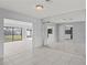 Living room with tile floors, mirrored walls, and access to Florida room at 2502 Indigo Dr, Dunedin, FL 34698