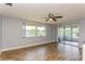 Bright living room with wood-look tile floors and access to a screened porch at 4145 Star Island Dr, Holiday, FL 34691