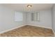 Spacious bedroom with light walls, wood-look tile floor and two windows at 4145 Star Island Dr, Holiday, FL 34691