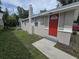 Charming single story home with a red front door and landscaped yard at 1158 Palmetto St, Clearwater, FL 33755