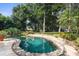 Relaxing freeform pool surrounded by lush landscaping and stone accents at 2901 Leprechaun Ln, Palm Harbor, FL 34683