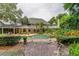 Brick pathway leads to a beautiful pool and patio area in a lush garden at 2901 Leprechaun Ln, Palm Harbor, FL 34683