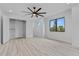 A minimalist bedroom with light wood floors, black framed windows, and built-in shelving, offering storage at 2121 Bayou Grande Ne Blvd, St Petersburg, FL 33703