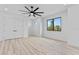 A minimalist bedroom with light wood floors, black framed windows, and white doors, offering a serene space at 2121 Bayou Grande Ne Blvd, St Petersburg, FL 33703