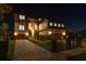 Eye-catching two-story home with stone accents, lush landscape, and paver driveway fence highlighted at night at 2121 Bayou Grande Ne Blvd, St Petersburg, FL 33703