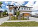 Modern home with stone accents, a fenced yard, a two-car garage, and meticulous landscaping on a sunny day at 2121 Bayou Grande Ne Blvd, St Petersburg, FL 33703