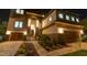 Gorgeous two-story home with stone accents, manicured landscape, and paver driveway highlighted at night at 2121 Bayou Grande Ne Blvd, St Petersburg, FL 33703