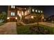 Spectacular two-story home featuring stone accents, a paver driveway, and lush landscaping illuminated at night at 2121 Bayou Grande Ne Blvd, St Petersburg, FL 33703