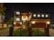 Magnificent two-story home with stone accents, well-lit windows, manicured lawn and a paver driveway at night at 2121 Bayou Grande Ne Blvd, St Petersburg, FL 33703