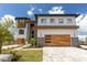 Modern home showcasing a two-car garage, stone accents, beautifully landscaped yard, and a wide driveway at 2121 Bayou Grande Ne Blvd, St Petersburg, FL 33703