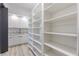 Walk-in pantry featuring white shelving and cabinets with marble countertops and light wood flooring at 2121 Bayou Grande Ne Blvd, St Petersburg, FL 33703
