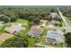 Aerial view of house in a residential neighborhood with pool and lush green lawn at 1086 Overland Dr, Spring Hill, FL 34608