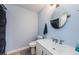 Bathroom with toilet and vanity; features a sleek mirror and light blue walls at 2323 Feather Sound Dr # 202, Clearwater, FL 33762