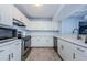 Modern kitchen featuring white cabinets, stainless steel appliances, and quartz countertops at 2323 Feather Sound Dr # 202, Clearwater, FL 33762
