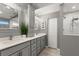 Updated bathroom with double vanity, gray cabinets, and a walk-in shower at 2376 Hanover Dr, Dunedin, FL 34698