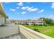 View from balcony shows lush green space and neighboring buildings at 2376 Hanover Dr, Dunedin, FL 34698