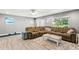 Living room with large sectional sofa and wood-look floors at 2376 Hanover Dr, Dunedin, FL 34698