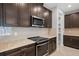 Modern kitchen with dark cabinets, granite countertops, and stainless steel appliances at 2503 Arch Ave # 139W, Oldsmar, FL 34677