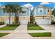 Two story townhome with a yellow and blue exterior, two car garage and landscaping at 2503 Arch Ave # 139W, Oldsmar, FL 34677