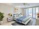 Serene bedroom with neutral walls, plush bedding, access to a balcony, and a ceiling fan at 100 Oakmont Ln # 301, Belleair, FL 33756
