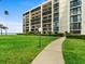 Beautiful condo building surrounded by lush green lawn, providing a serene and welcoming environment at 100 Oakmont Ln # 301, Belleair, FL 33756