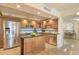 Modern kitchen with stainless steel appliances, granite countertops, wooden cabinets, and a central island at 100 Oakmont Ln # 301, Belleair, FL 33756