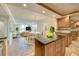 Open-concept living room and kitchen, featuring stainless appliances, wooden cabinets, and a cozy dining area at 100 Oakmont Ln # 301, Belleair, FL 33756