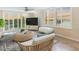 Bright living room featuring a ceiling fan, tile floors, a woven coffee table, and waterfront views at 100 Oakmont Ln # 301, Belleair, FL 33756