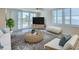Bright living room featuring a woven coffee table and waterfront views at 100 Oakmont Ln # 301, Belleair, FL 33756