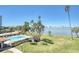 A ground level view of a waterway, pool, palms trees, and skyline at 100 Oakmont Ln # 301, Belleair, FL 33756