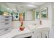 Bathroom showcasing a sink with a large mirror and under-cabinet storage, set against bright white tile, with a warm inviting ambiance at 1172 Chelsea Ln, Holiday, FL 34691