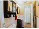 Bathroom with dark cabinets, white tile, and wood-look flooring. It features a unique sink and a cabinet with a mirror at 1172 Chelsea Ln, Holiday, FL 34691