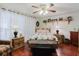 Bedroom featuring wood flooring, soft lighting, and a decorative quilt, with an attractive ceiling fan at 1172 Chelsea Ln, Holiday, FL 34691