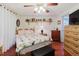 Bedroom showcasing a wooden bed, matching nightstands, and wood flooring. A view to the exterior is visible through a door at 1172 Chelsea Ln, Holiday, FL 34691
