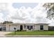 The front of a cozy home showcasing landscaping and a decorative front door and attached garage at 1172 Chelsea Ln, Holiday, FL 34691