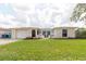 Charming home with a well-maintained lawn, decorative front door, and attached one-car garage at 1172 Chelsea Ln, Holiday, FL 34691