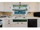 Inviting kitchen featuring ample counter space, white cabinets, and a bright window with a garden view at 1172 Chelsea Ln, Holiday, FL 34691