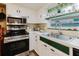 Well-equipped kitchen with stainless steel appliances, white cabinetry, and garden window at 1172 Chelsea Ln, Holiday, FL 34691