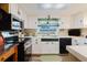Charming kitchen featuring a stainless steel oven, black dishwasher, and a window with a garden view at 1172 Chelsea Ln, Holiday, FL 34691
