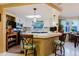 Bright kitchen view features white cabinets and a breakfast bar with decorative stools and lighting at 1172 Chelsea Ln, Holiday, FL 34691