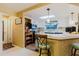 Well-lit view of the kitchen with white cabinets and a breakfast bar with decorative stools at 1172 Chelsea Ln, Holiday, FL 34691