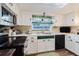 Bright kitchen showcasing white cabinets, stainless steel appliances, and a window offering natural light at 1172 Chelsea Ln, Holiday, FL 34691