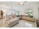 Open and bright living room with a large sectional sofa, adjacent to the dining area at 21811 Lyonia Ln, Land O Lakes, FL 34637