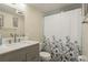 Clean bathroom with a shower/tub combo, updated vanity, and decorative shower curtain at 5245 Amulet Dr # 306, New Port Richey, FL 34652